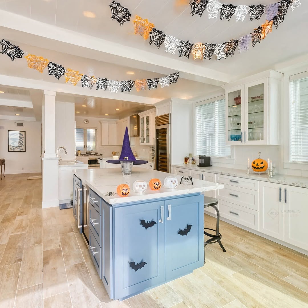 Modern kitchen decorated for Halloween with bat and spiderweb garlands, jack-o
