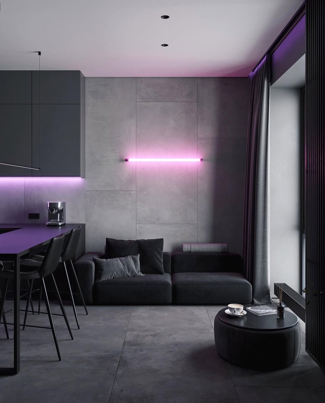 Modern black living room with grey walls, sleek black furniture, a cozy black sofa, bar stools, a round ottoman, and vibrant pink LED lighting above the sofa and kitchen counter.