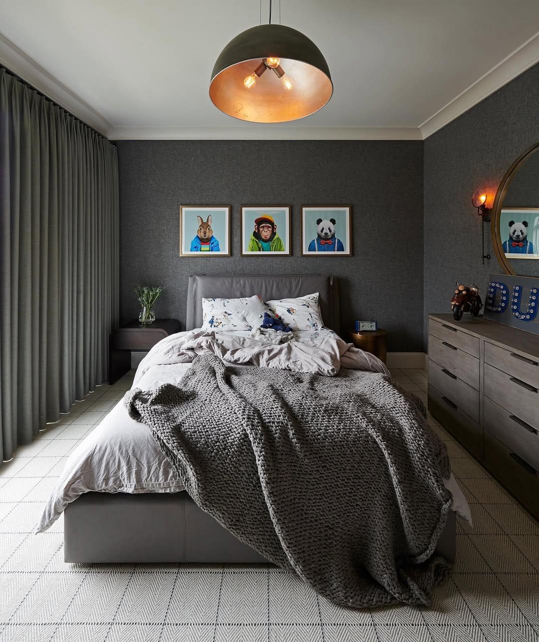 A modern boys bedroom idea featuring a gray bed, textured blanket, three animal portraits on the wall, a dresser with smart storage solutions, curtains, and a sleek ceiling light fixture—perfect for stylish and functional sleep spaces.