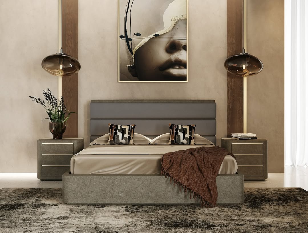 Modern Italian bedroom with a gray upholstered bed, neutral bedding, two nightstands, pendant lights, a plant, and abstract art above the headboard. Light-colored walls and a textured rug complete the stylish look.
