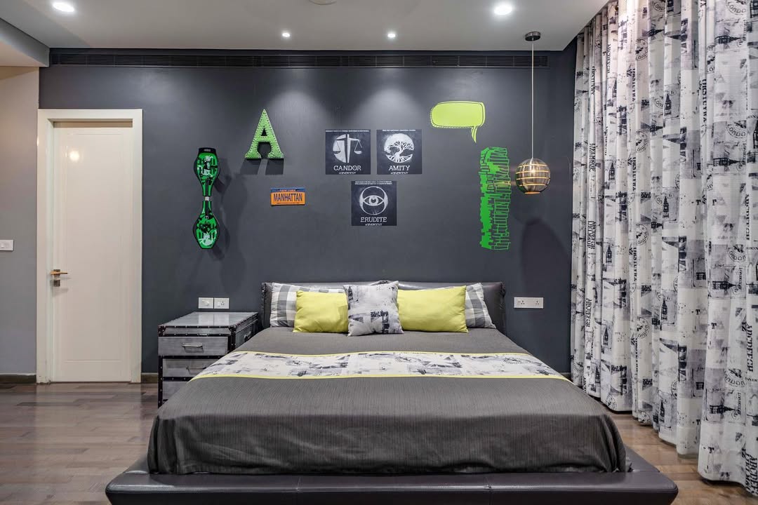 Modern boys bedroom ideas include a gray accent wall, wall art, double bed with gray and yellow bedding, curtains with a black-and-white print, smart storage solutions, and a hanging light fixture for a cozy sleep environment.