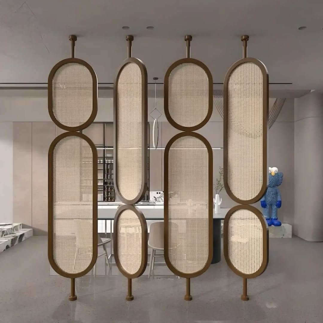 Room divider with six oval mesh panels on metal rods separates a modern kitchen and dining area, offering instant style for stylish homeowners; a blue bear sculpture stands near the wall in the background.