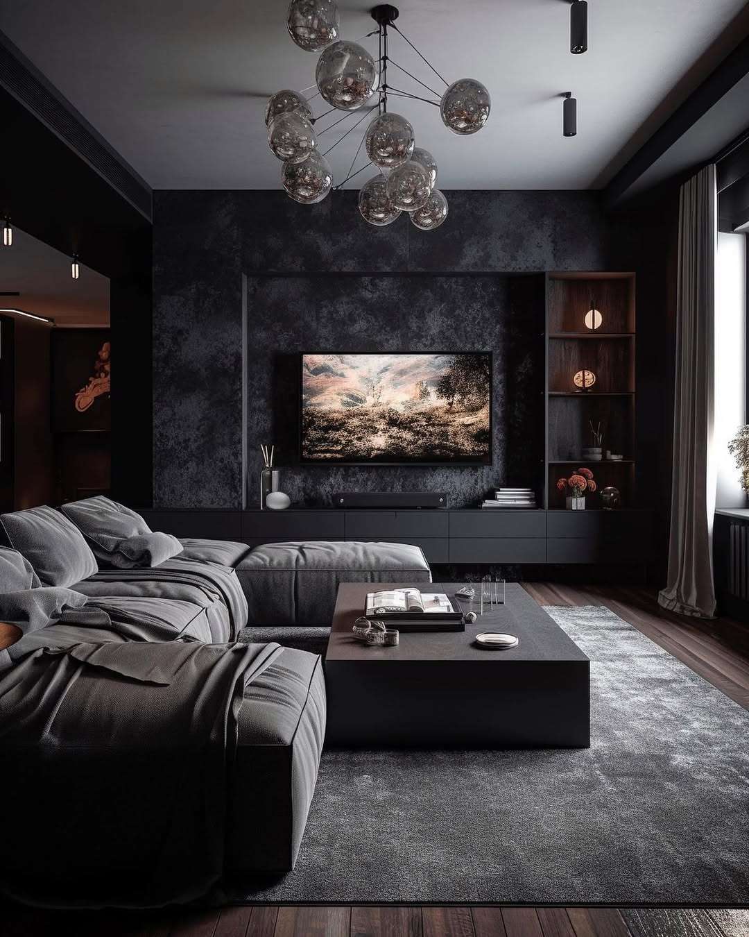 Modern black living room with dark walls, a large sectional sofa, a rectangular coffee table, wall-mounted TV, open shelving, and a cluster glass chandelier. Natural light streams in from the window.