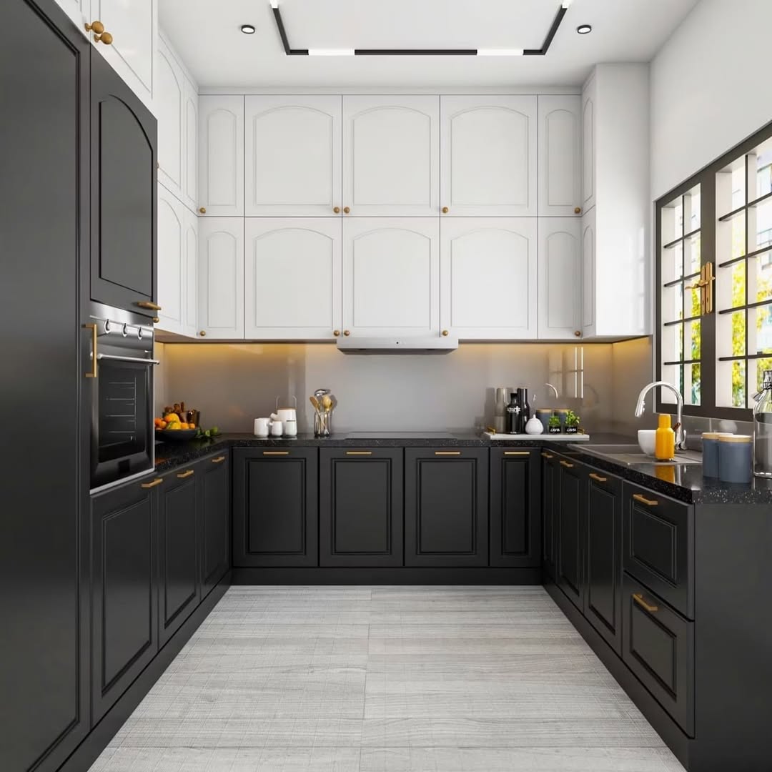 Modern kitchen with black lower cabinets, white uppers, gold hardware, built-in oven, and a large window illuminating the gray tiled floor and sleek black countertop kitchen design.