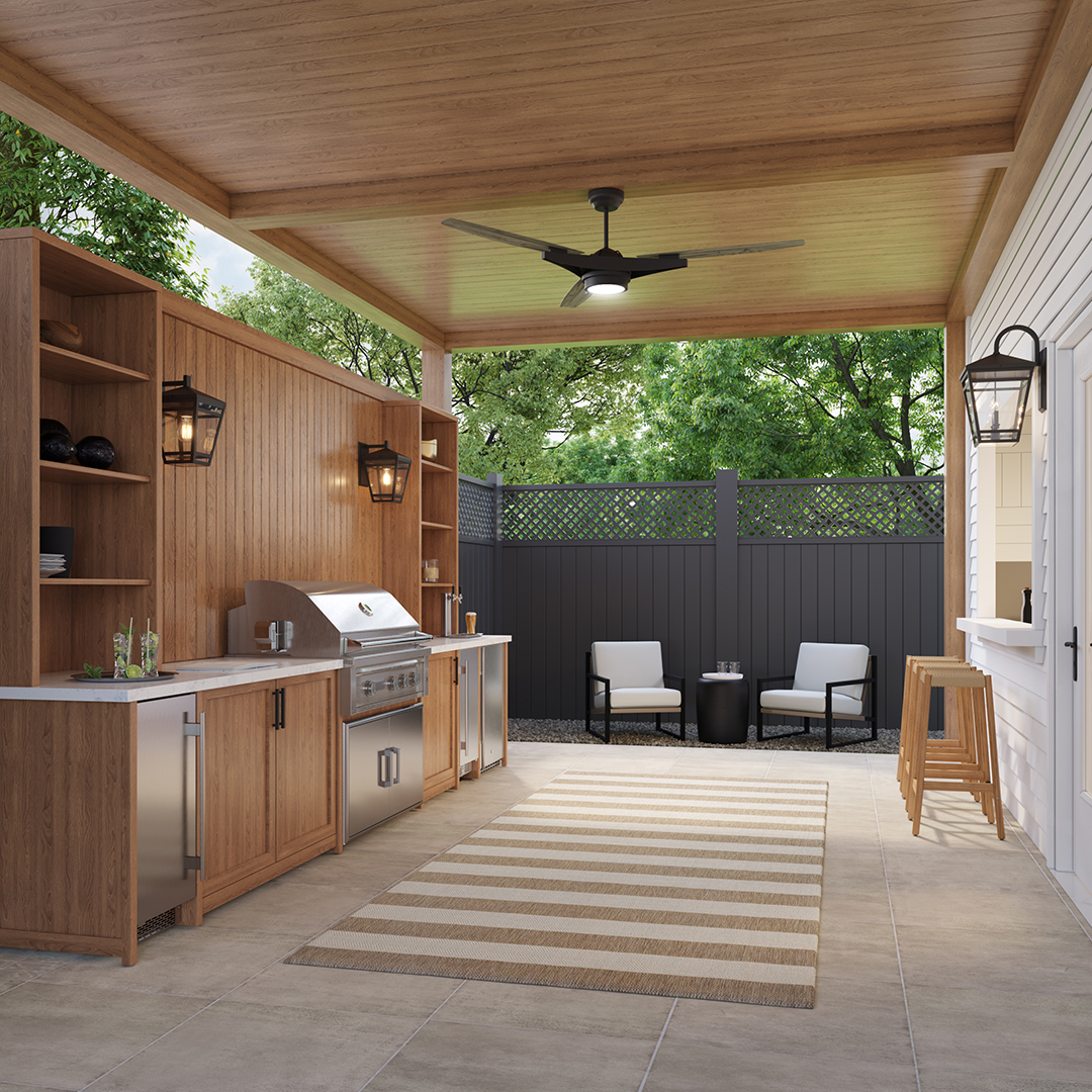 This rustic outdoor kitchen features wood cabinets, stainless steel appliances, an overhead fan, a striped rug, and two chairs in a fenced patio area under a wooden roof—perfect for those seeking inspiring outdoor kitchen ideas.