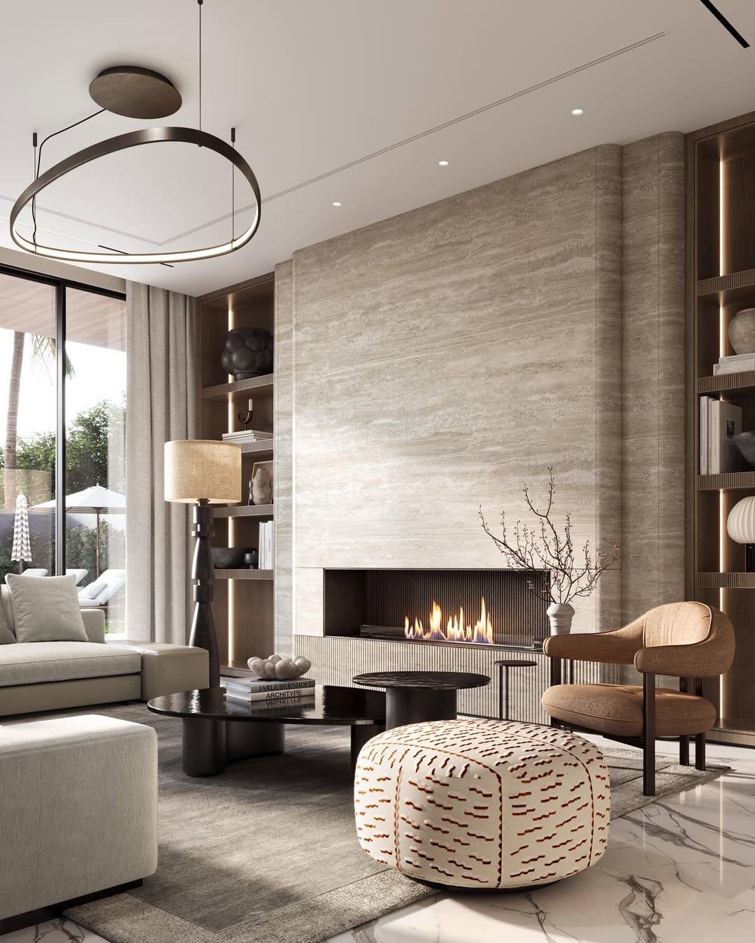 Modern Living Room with a beige stone fireplace, contemporary furniture, large windows, built-in shelves, and a cozy lit fire. Natural light pours in from sliding glass doors on the left.